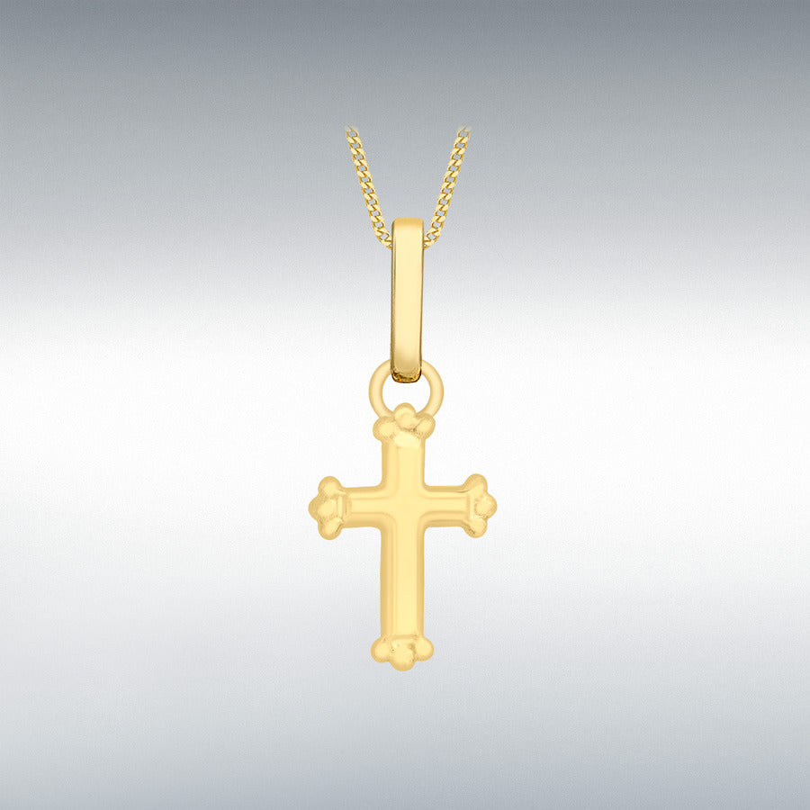 Gold cross pendant for children on a chain against a gray background