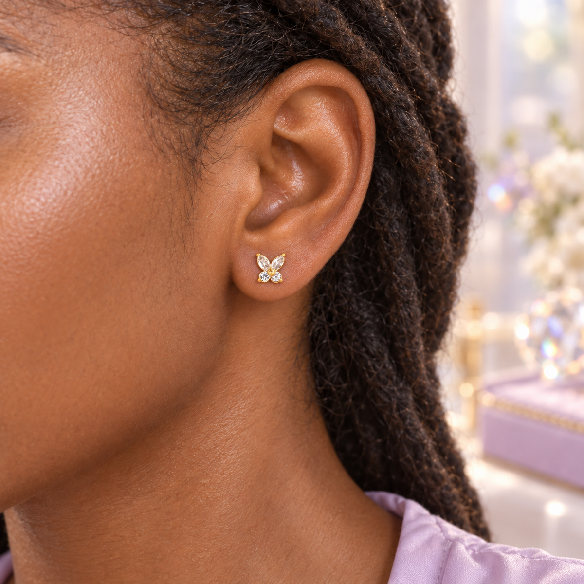 Gold crystal butterfly hypoallergenic flat back earring worn in a child’s ear