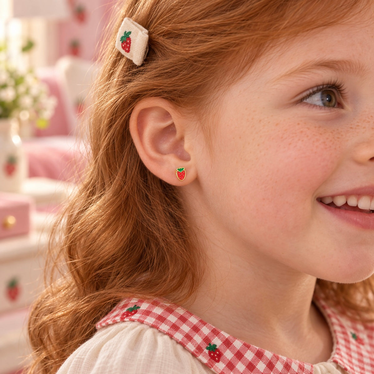 Strawberry hypoallergenic earring worn in a child’s ear, designed for sensitive ears