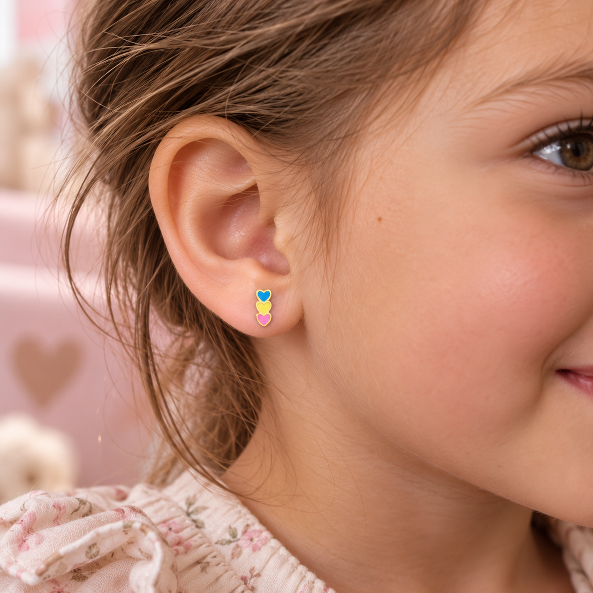 Three hearts hypoallergenic flat back earrings for children worn in a girl's ear